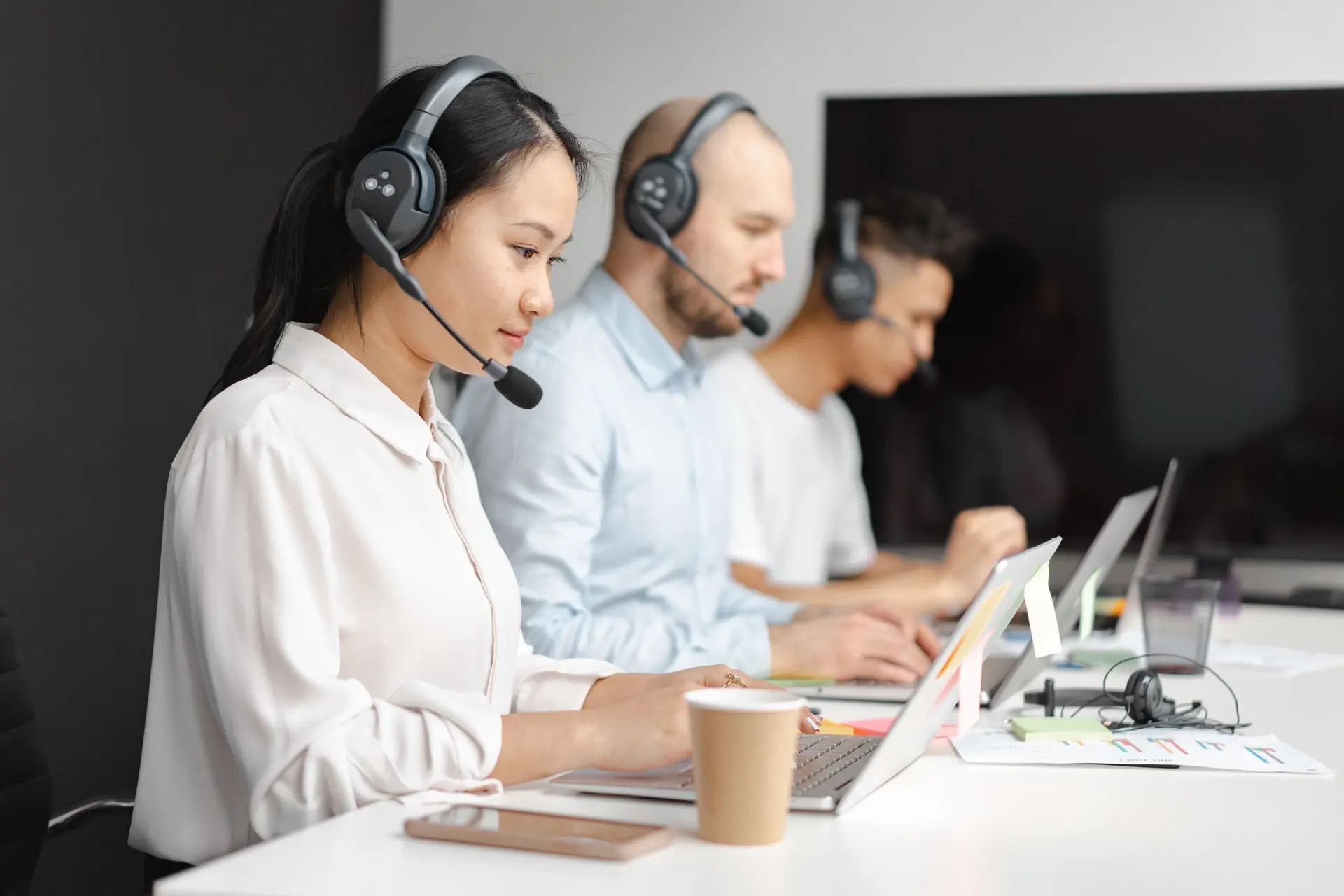 Équipe support avec casques téléphoniques dans un bureau lumineux